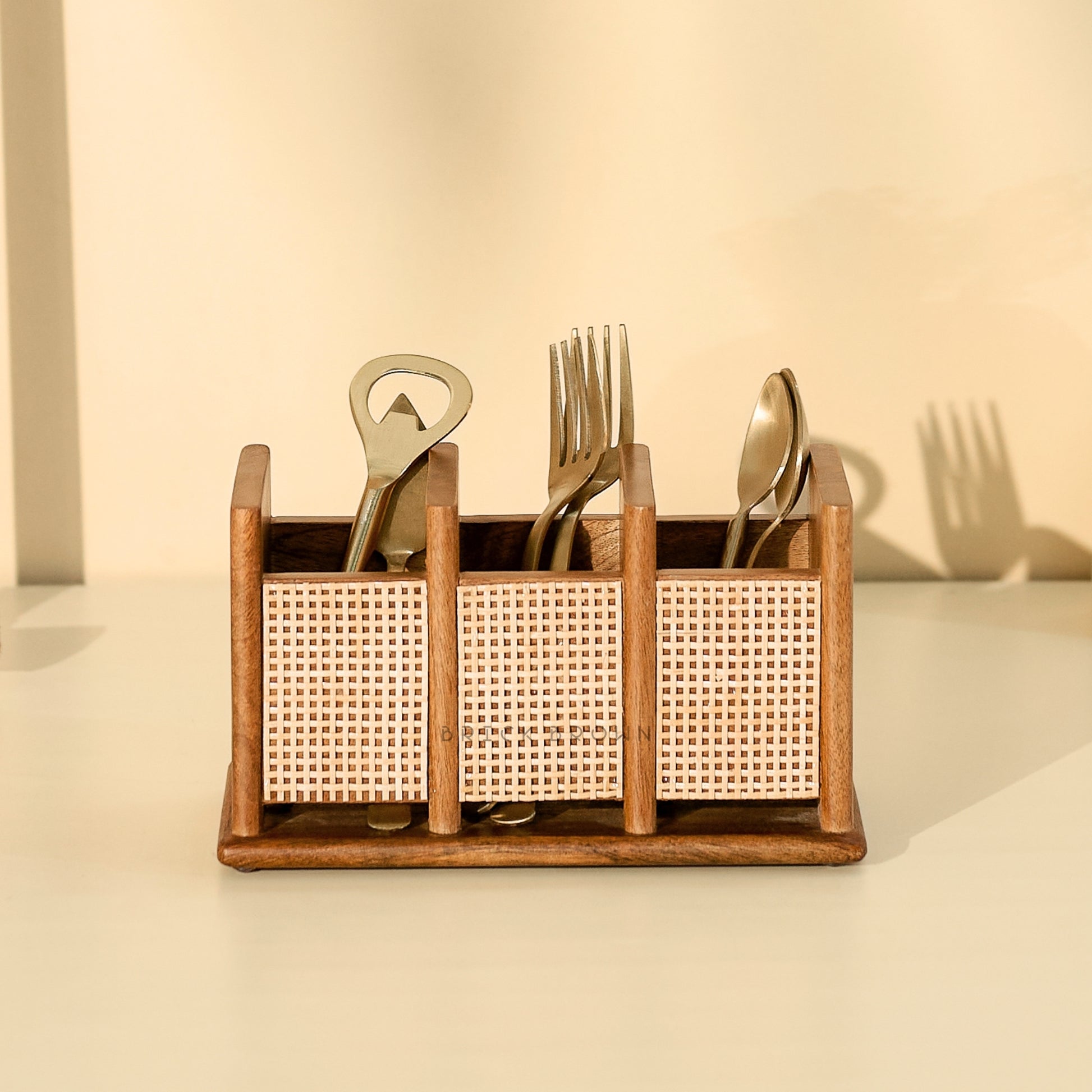 Wooden utensil holder with cutlery on a beige background